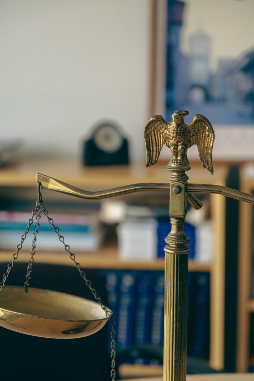 Brass scales of justice on a desk in the Law Office of Tracy A. Wong, P.A.
